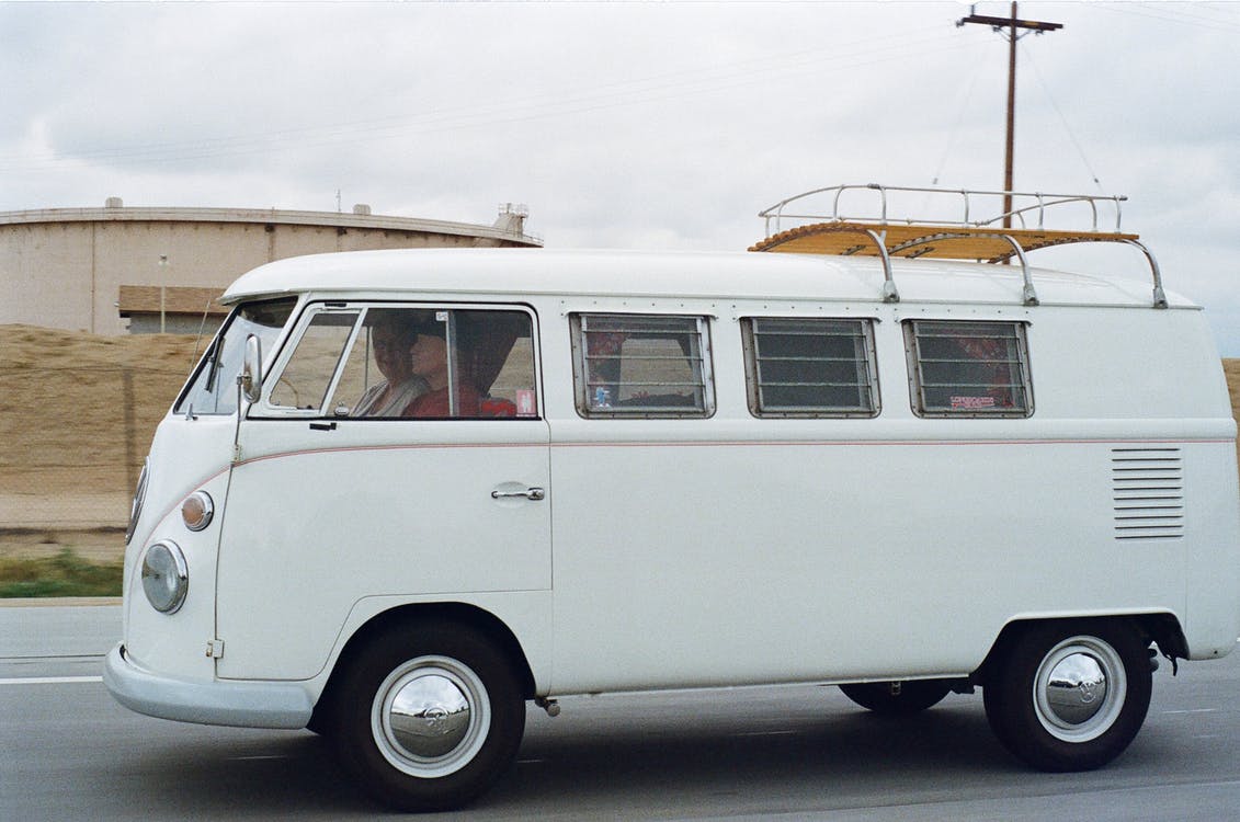 Two Person Riding White Volkswagen T2