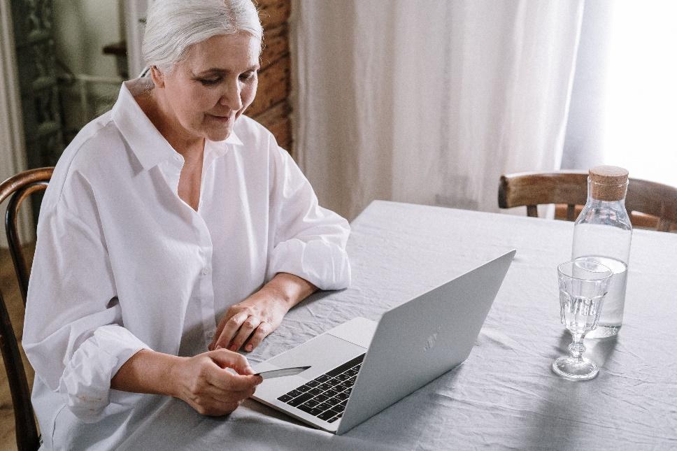 A person sitting at a table using a computer Description automatically generated